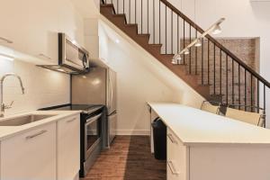 a kitchen with white cabinets and a staircase at Meramont Hotel Downtown in Montreal
