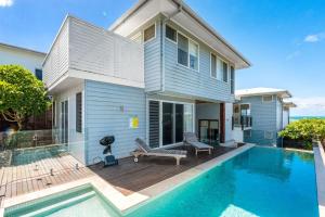 a house with a swimming pool in front of a house at The Beach House in Lennox Head