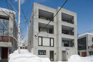 a tall building with snow in front of it at Cecuko A in Kutchan