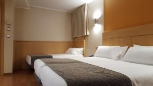 2 letti in camera d'albergo con cuscini bianchi di Espel ad Andorra la Vella