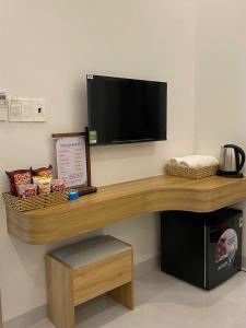 a desk with a flat screen tv on a wall at Luxury Hotel Long Thành in Xóm Nước Trong