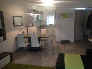 - une cuisine et une salle à manger avec une table et des chaises dans l'établissement ZEN Apartman Sunshine, à Zamárdi