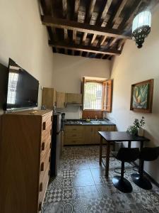 a kitchen with a table and a kitchen with a tv at Casa del Patio in Guadalajara