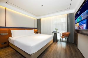 a bedroom with a large white bed and a tv at Mehood Hotel Xi'an Tumen Railway Station in Xi'an +32 photos