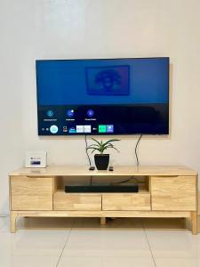 a wooden entertainment center with a large flat screen tv at Kings hotel Ph in Manila +6 photos