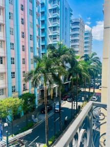 a city street with palm trees and tall buildings at Kings hotel Ph in Manila