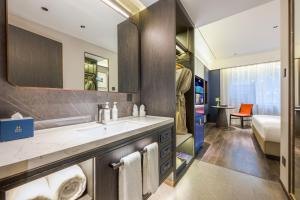 a bathroom with a sink and a bed in a room at Mehood Hotel Xi'an Tumen Railway Station in Xi'an