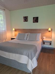 a bedroom with a large bed with two tables and two lamps at Cabaña Corolaine in San Francisco