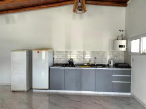 a kitchen with stainless steel cabinets and a refrigerator at El Chiringuito in Paraná
