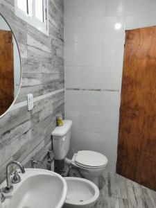 a bathroom with a toilet and a sink and a mirror at El Chiringuito in Paraná