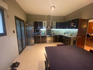 a kitchen with a table and a kitchen with stainless steel appliances at Casa Quinta in Córdoba