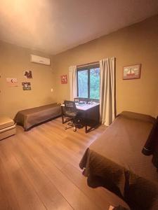 a bedroom with two beds and a desk and a window at Casa Quinta in Córdoba