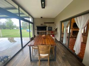 a dining room with a wooden table and a large window at Casa Quinta in Córdoba