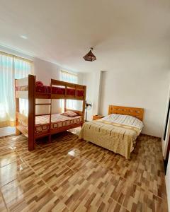 a bedroom with two bunk beds and a wooden floor at Casa Norte North Beach in Los Órganos +19 photos