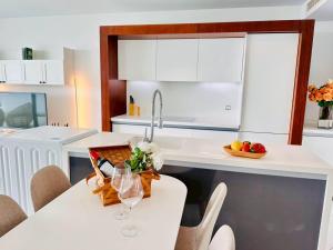 a kitchen with a table with wine glasses on it at Pure Sunset Beach - By Mikihollick in Na Jomtien