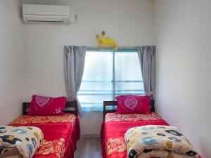 two beds in a room with a window at 旅館さくら in Takamatsu