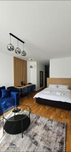 a bedroom with a large bed and a blue couch at Zlatni TRG in Zlatibor