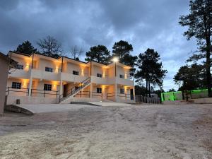 a large white building with lights on at HOTEL Y CABAÑAS El PINO in Creel
