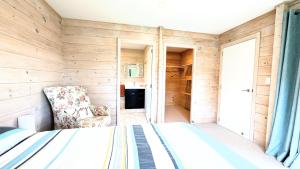 a bedroom with a bed and a chair in a room at Absolute Tranquility - surrounded by native bush in Kaiuma