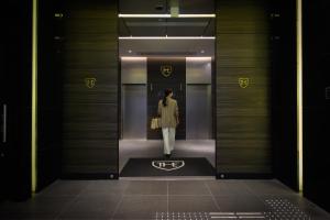 a woman walking through a elevator in a building at The Royal Park Canvas Nagoya in Nagoya