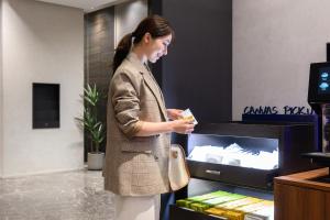 a woman standing in front of a cash register at The Royal Park Canvas Nagoya in Nagoya