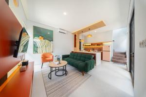 a living room with a green couch and a table at Villa Vatama Jimbaran in Jimbaran +137 photos