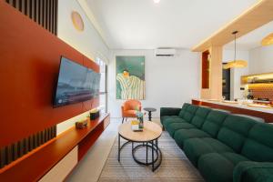 a living room with a green couch and a tv at Villa Vatama Jimbaran in Jimbaran