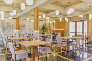a restaurant with wooden tables and chairs and lights at Leśny Dwór in Radom
