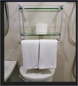 a bathroom with towels on a toilet and a sink at Rana Hotel in Sampong