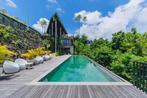 a swimming pool on a deck with a house at Villa Vatama Jimbaran in Jimbaran