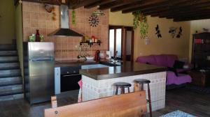 cocina con nevera y encimera en Casa Rural Rosa Magica, en Lancharejo
