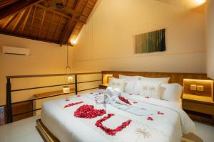 a bedroom with a bed with red flowers on it at Sleepwell Seminyak in Seminyak +43 photos