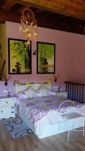 a bedroom with a white bed and a chandelier at Casa Rural Rosa Magica in Lancharejo