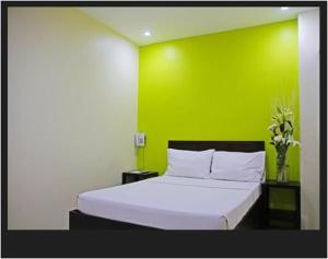 a bedroom with a white bed with a green wall at Rana Hotel in Sampong +15 photos