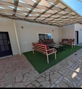 a living room with two chairs and a table at شالية نخلة in Buraydah