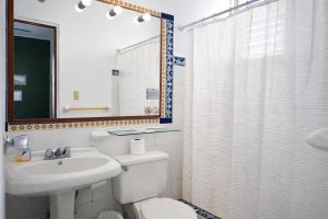 a bathroom with a toilet and a sink and a shower at Hotel 1492 in San José