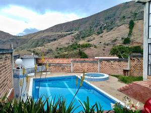a house with a swimming pool and a mountain at Casa Finca de verano in Chachagüí
