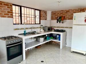 a kitchen with a sink and a stove and a refrigerator at Casa Finca de verano in Chachagüí