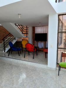 a room with chairs and a table and a television at Casa Finca de verano in Chachagüí