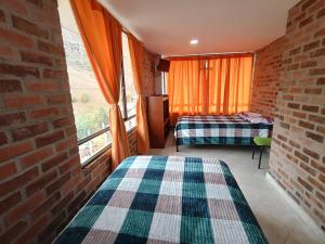 a room with two beds and a brick wall at Casa Finca de verano in Chachagüí