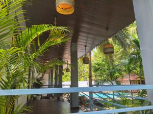 a balcony with palm trees and potted plants at Sarovar Morjim in Morjim