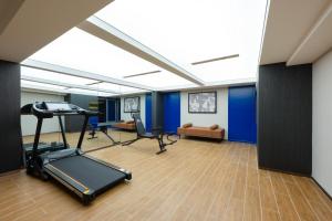an office with a treadmill and a room with blue walls at Mehood Hotel Xi'an Tumen Railway Station in Xi'an