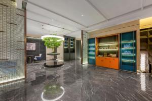 a lobby of a hotel with a plant in a vase at Mehood Hotel Xi'an Tumen Railway Station in Xi'an