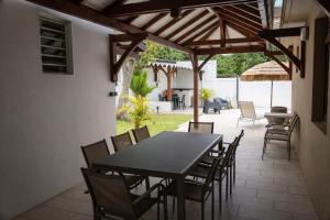 a dining table and chairs on a patio at Le cocon de Josie avec Jacuzzi & Piscine Privée, Le Lamentin, Martinique in Le Lamentin