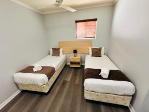 a room with two beds and a window at Caloundra Central Apartment Hotel Official in Caloundra