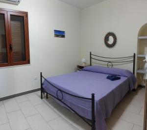 ヴィッラシミーウスにあるDomus Incaniのベッドルーム1室(紫のシーツが敷かれたベッド1台、窓付)