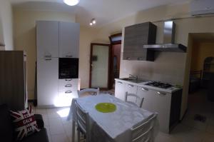 a kitchen with a table and a kitchen with white cabinets at Domus Incani in Villasimius