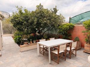 a white table and chairs on a patio with trees at Manyolas 93 in Alaró