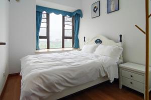 a bedroom with a white bed and a window at WeChat user-s store in Gongche