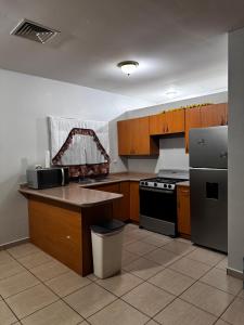 a kitchen with wooden cabinets and a stove and refrigerator at Villa Bonita in La Ceiba